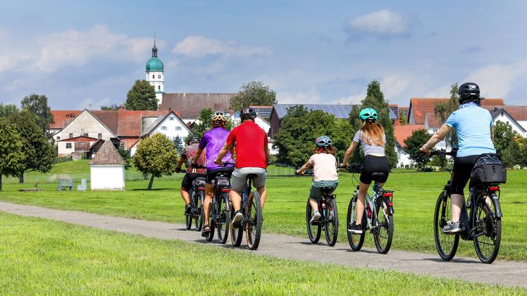 Baden-Württemberg, Seekirch: Radfahrer sind bei Sonnenschein auf dem Federsee-Rundweg bei Seekirch unterwegs