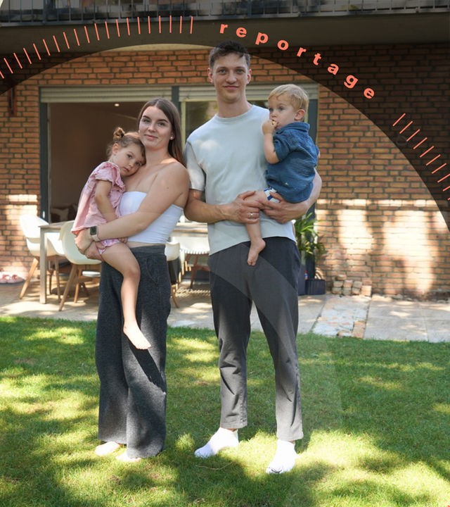 Katharina und Jannik S. stehen im Garten vor einem Haus. Sie haben ihre beiden Kinder auf dem Arm.