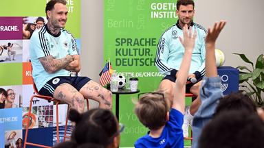 USA, Chicago: Fußball: Nationalmannschaft, vor dem WM-Start am 11. Juni, David Raum (Deutschland) und Leon Goretzka (Deutschland) sprechen mit Schülern im Goethe-Institut Chicago.