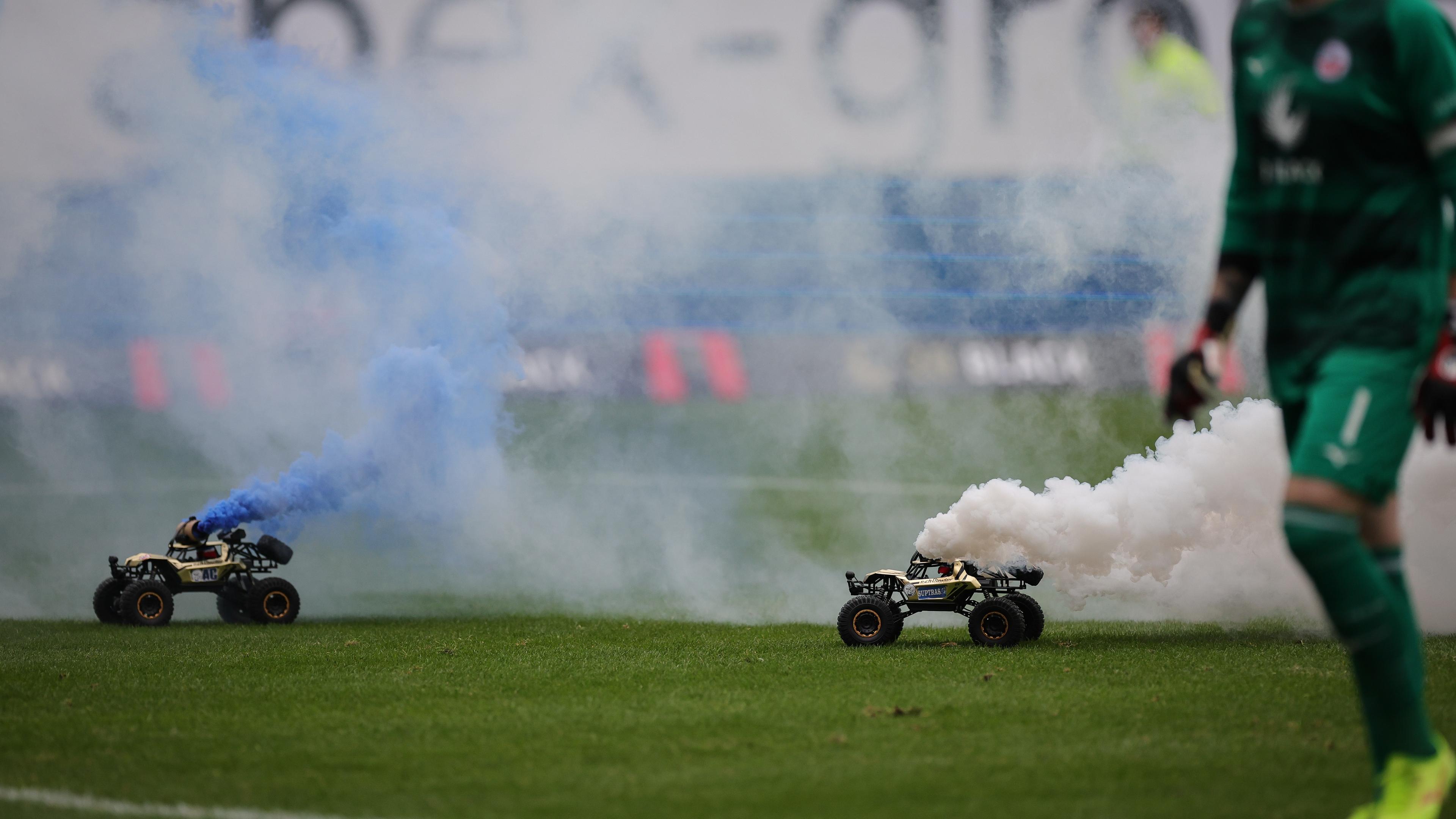 Rostock, 17.02.2024: Fans protestieren indem sie Spielzeugautos auf dem Spielfeld fahren lassen.