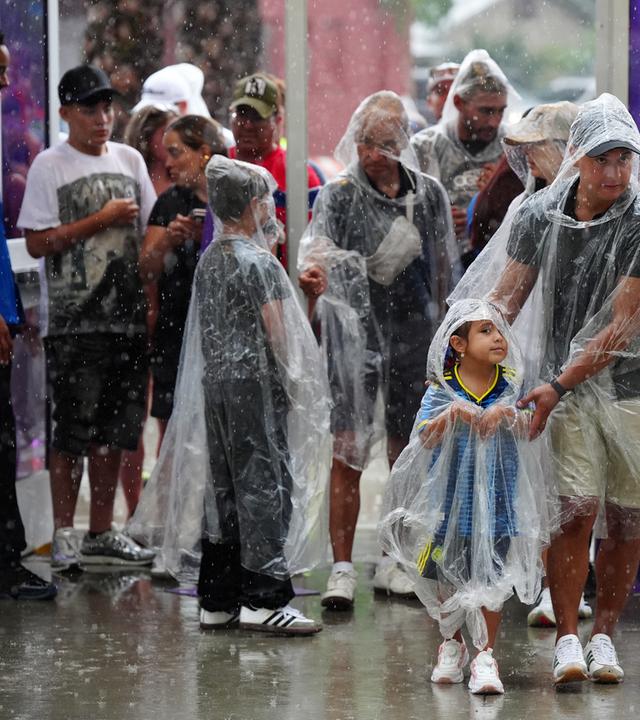 Fans im Regen, während sich der Anpfiff für Englands letztes WM-Vorbereitungsspiel gegen Costa Rica aufgrund stürmischen Wetters in Orlando verzögert. 