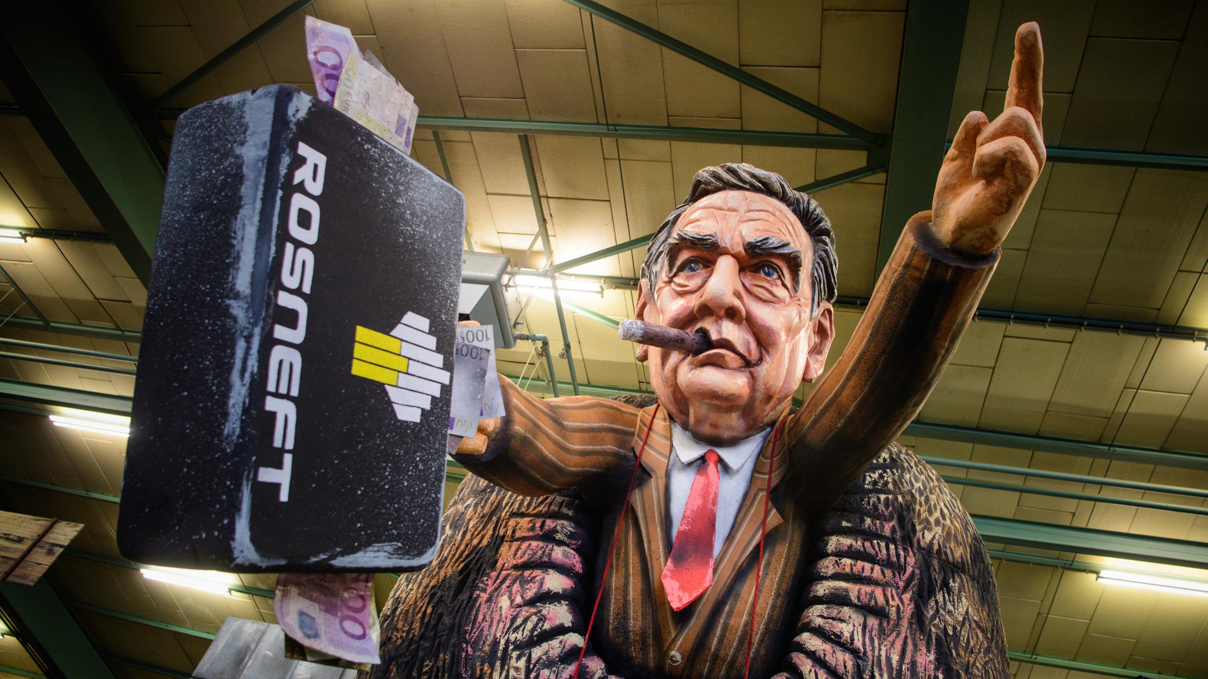 Gerhard Schröder (SPD) schaut mit Zigarre und Geldkoffer aus dem Hintern eines riesigen russischen Bären.