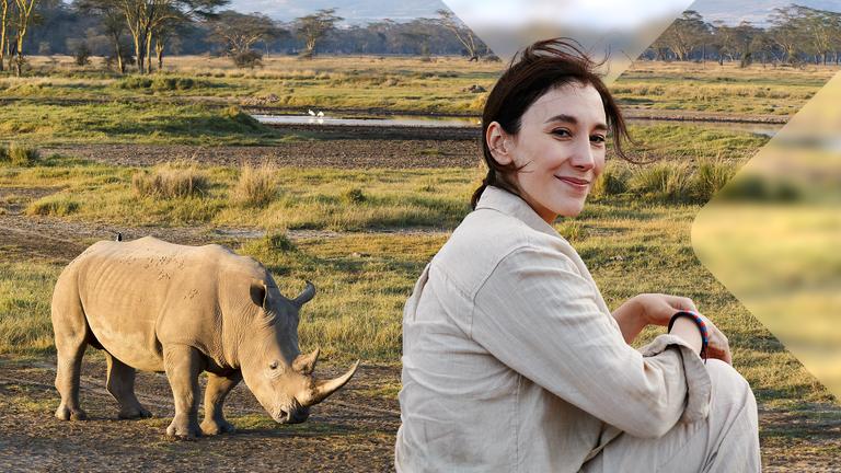 Sibel Kekilli sitzt in Savanne vor Nashorn
