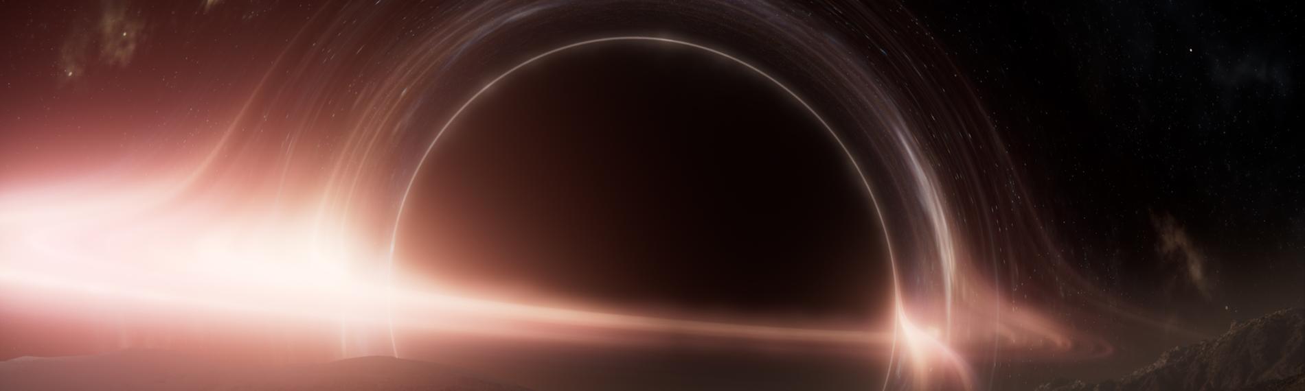 Computeranimation eines Schwarzen Lochs, das von leuchtenden Ringen umgeben ist. Im Vordergrund die felsige Oberfläche eines Planeten.