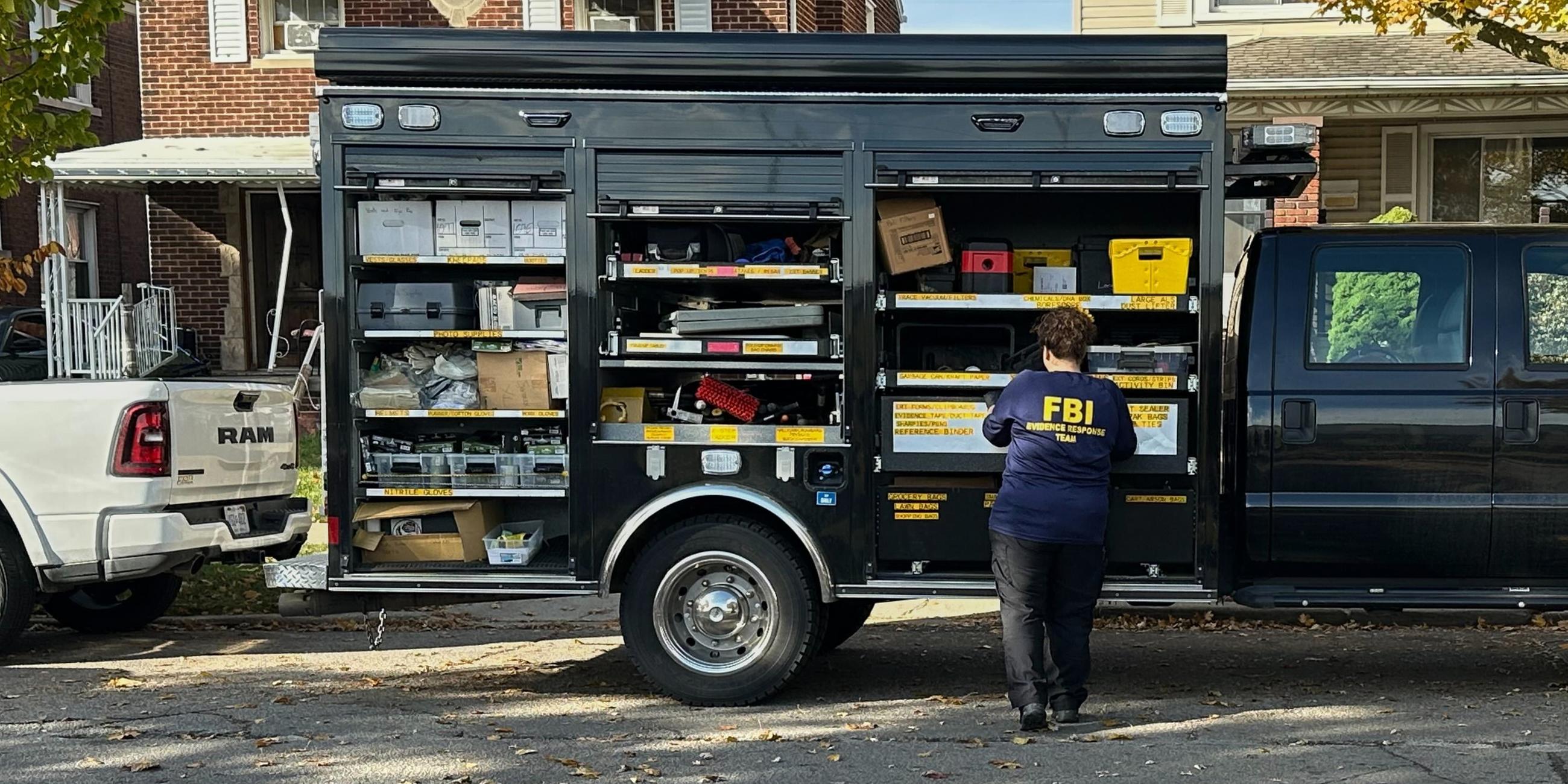 Ein FBI-Agent steht am Freitag, dem 31. Oktober 2025, neben einem Fahrzeug des Evidence Response Teams vor einem Haus in einem Wohngebiet in Dearborn, Michigan.