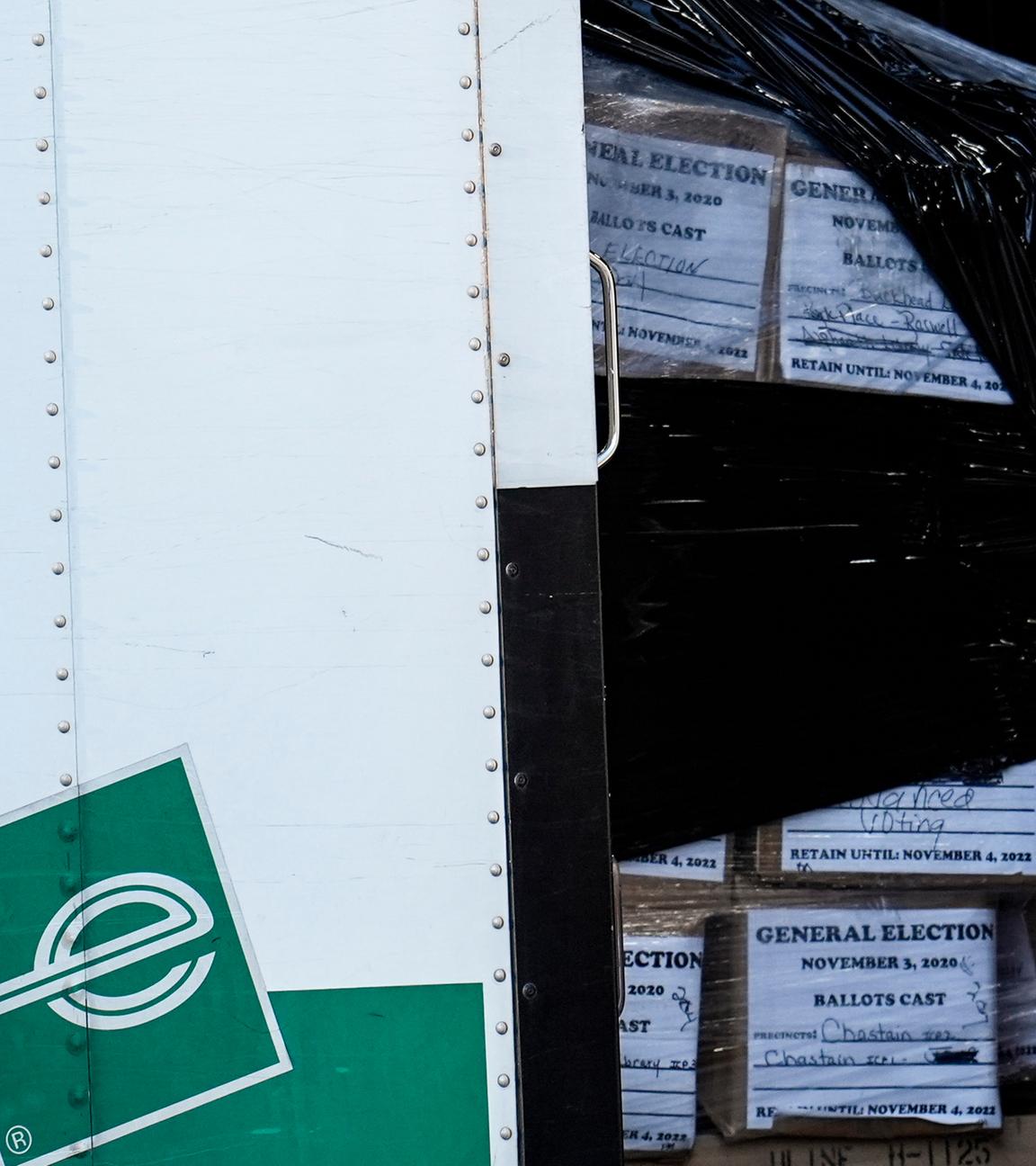 In einem großen Wagen befinden sich Kisten. In diesen Kisten sind die Stimmzettel der 2020 US-Wahl.