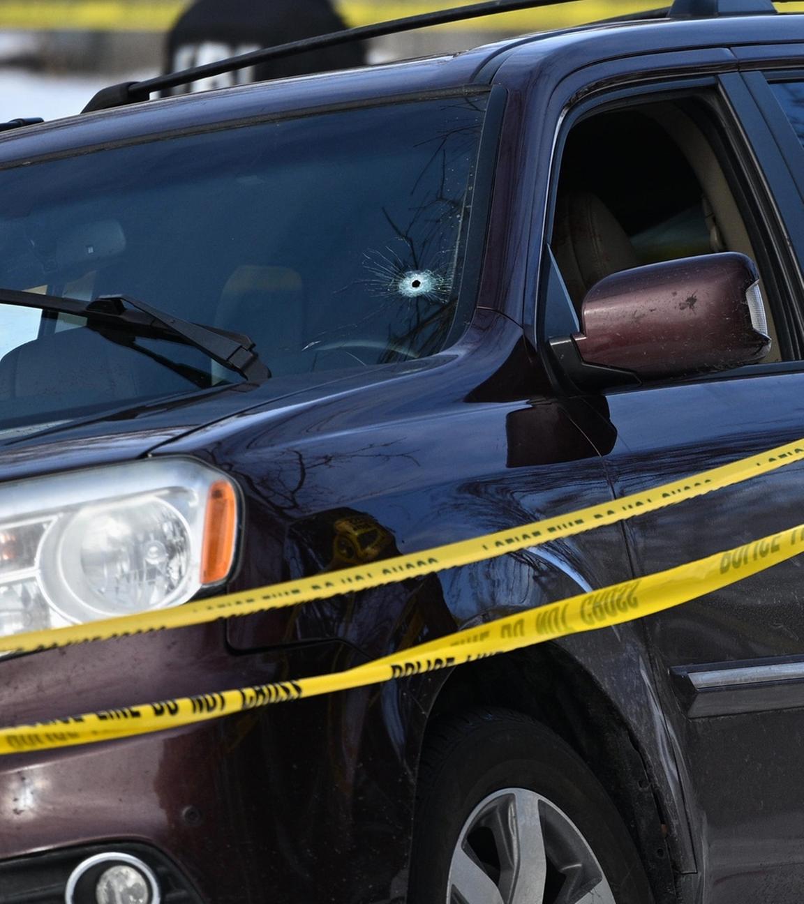 Ein Einschussloch in der Windschutzscheibe eines Autos ist zu sehen, als Beamte des FBI einen Tatort nach einem Einsatz untersuchen, an dem Bundespolizisten beteiligt waren.
