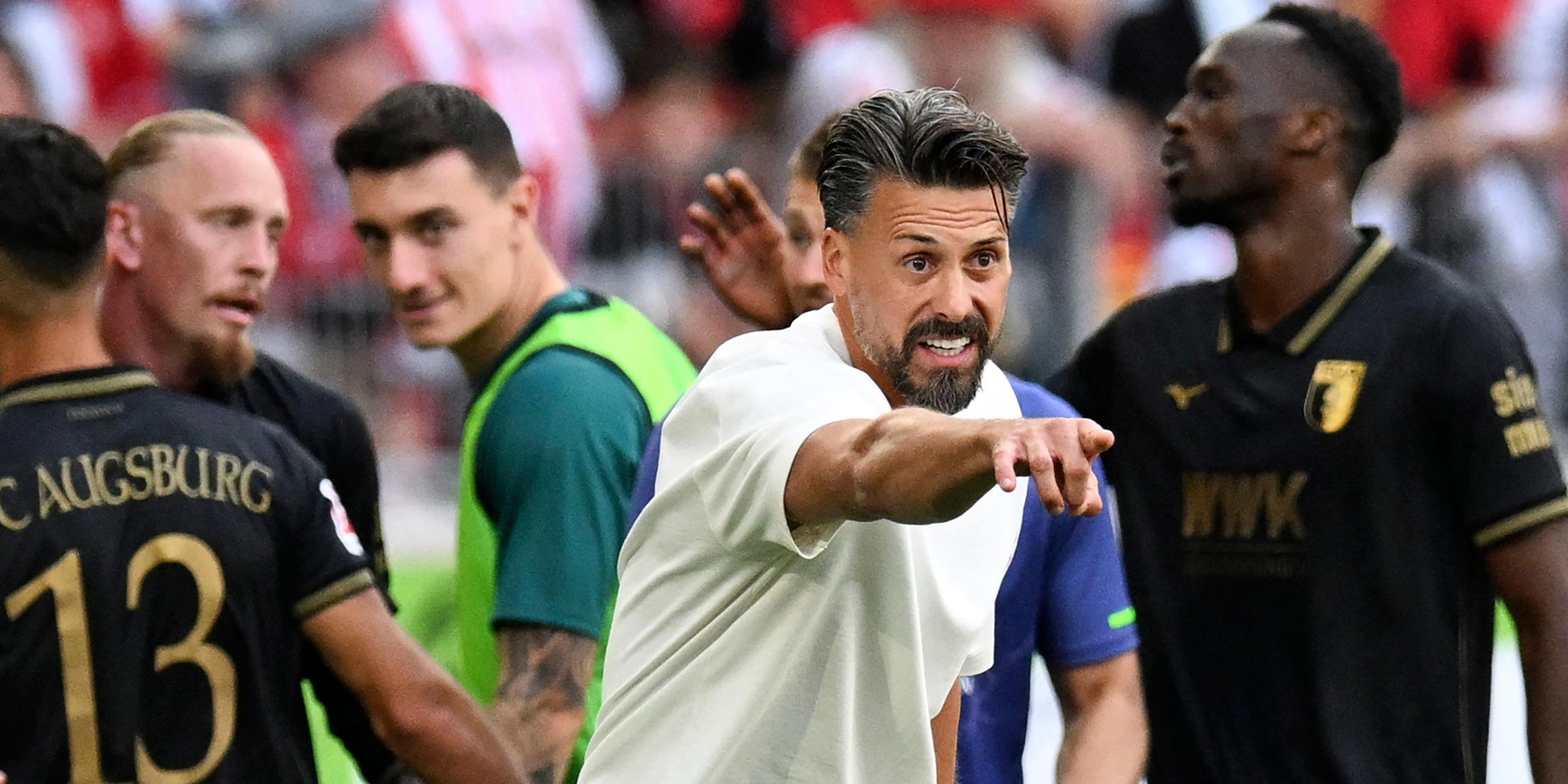 Augsburgs Trainer Sandro Wagner (M.) jubelt, während seine Spieler das dritte Tor im Bundesligaspiel gegen den SC Freiburg am 23. August 2025 in Freiburg feiern.