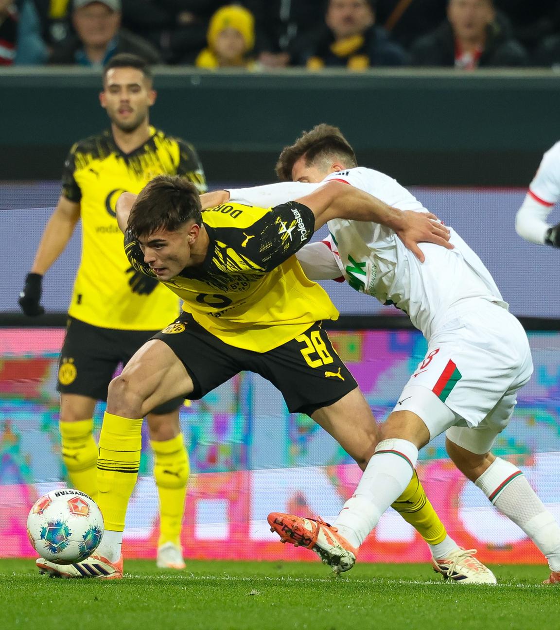 Im Zweikampf: Anselmino von Borussia Dortmund gegen Elvis Rexhbecaj (FC Augsburg)