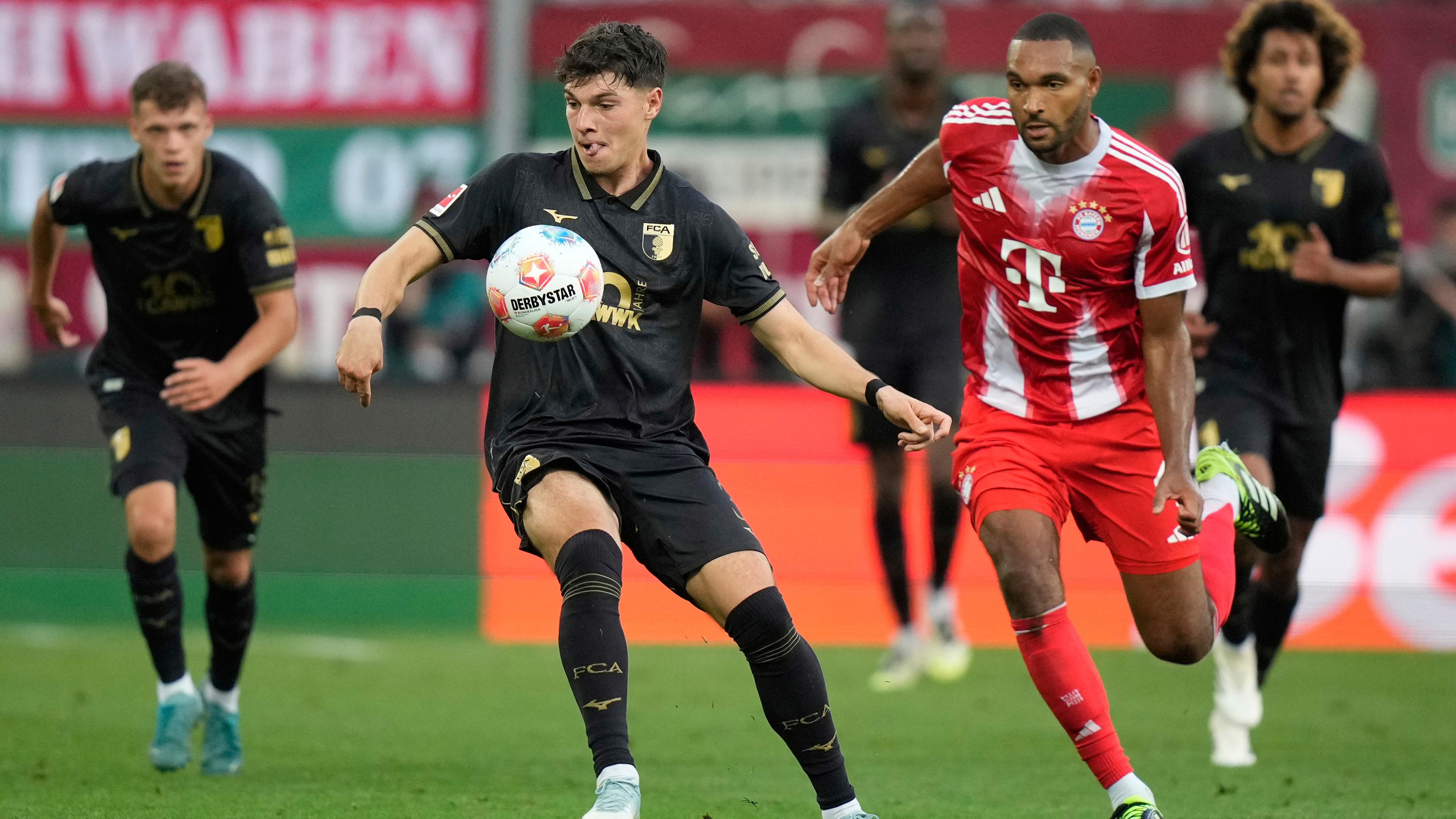 Die Spieler von FC Augsburg und FC Bayern München kämpfen.