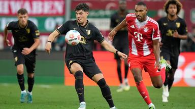 Die Spieler von FC Augsburg und FC Bayern München kämpfen.
