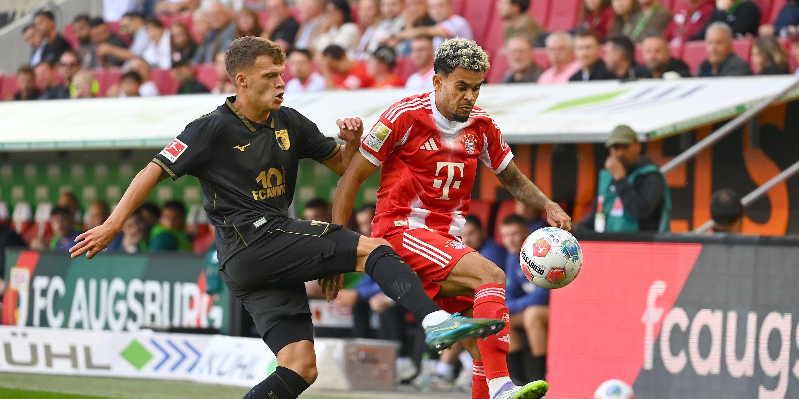 Die Spieler von FC Augsburg und FC Bayern München kämpfen.