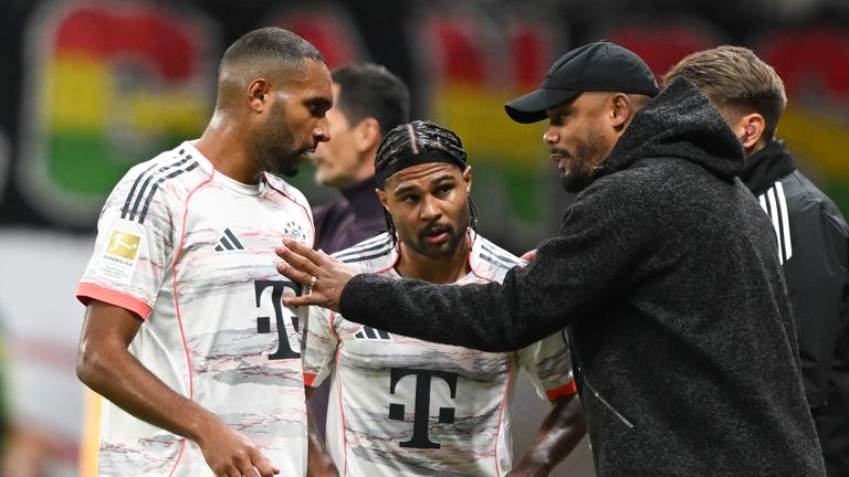 Bayern Münchens Trainer Vincent Kompany spricht an der Seitenlinie mit Jonathan Tah und Serge Gnabry.