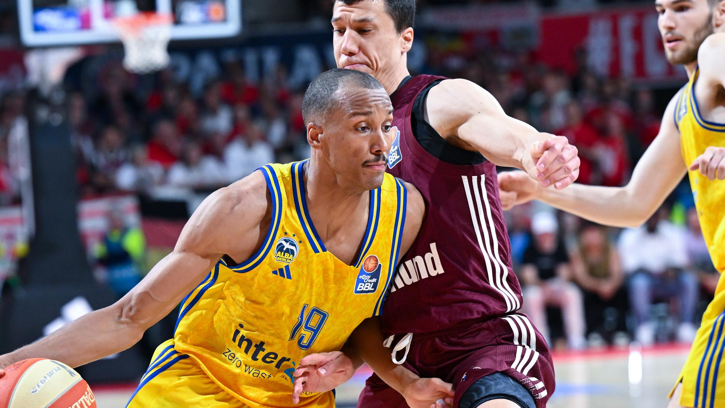 Vladimir Lucic (M) von München und Louis Olinde (l) von Berlin kämpfen um den Ball.