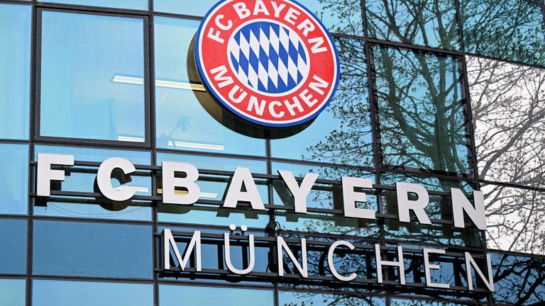 Logo und Schriftzug des FC Bayern München am Vereinsgelände.