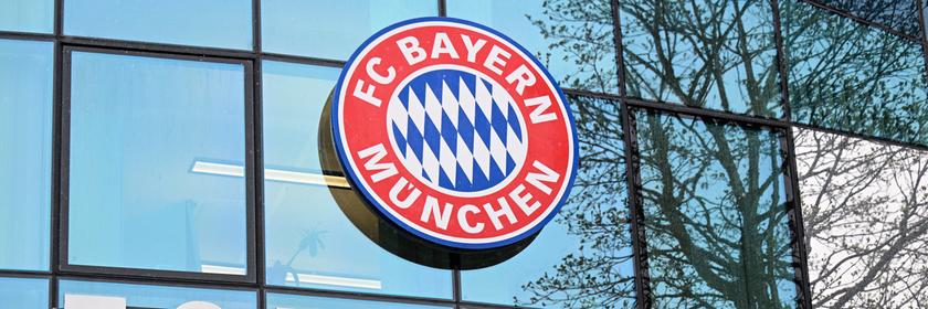 Logo und Schriftzug des FC Bayern München am Vereinsgelände.