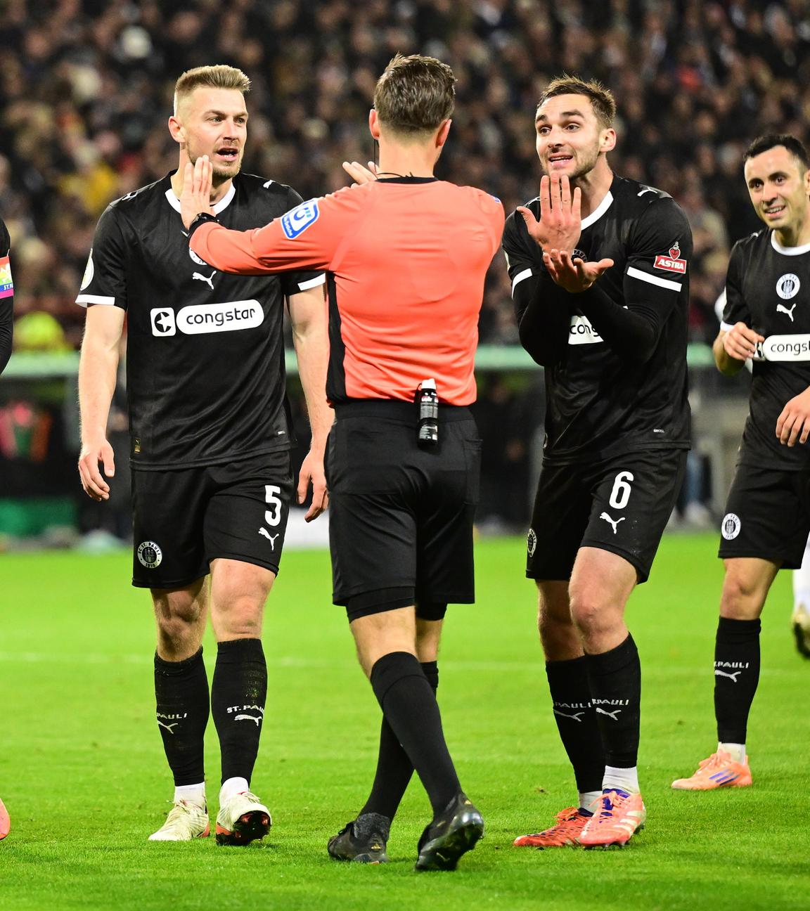 St.-Pauli-Spieler reden mit Schiedsrichter Schlager. 