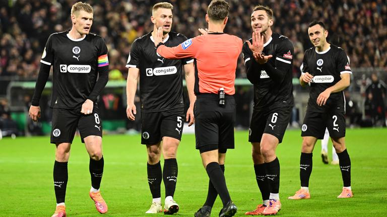 St.-Pauli-Spieler reden mit Schiedsrichter Schlager. 