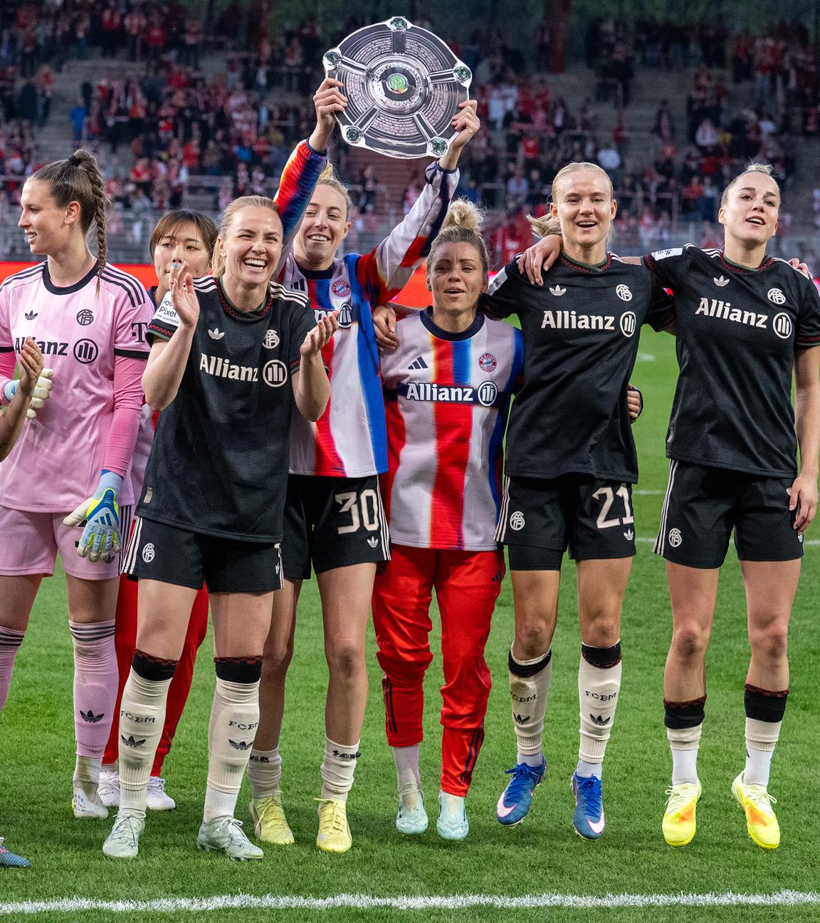 Die Spielerinnen von FC Bayern München jubeln nach dem Spielende mit einer Nachbildung der Meisterschale über den Sieg gegen 1. FC Union Berlin.