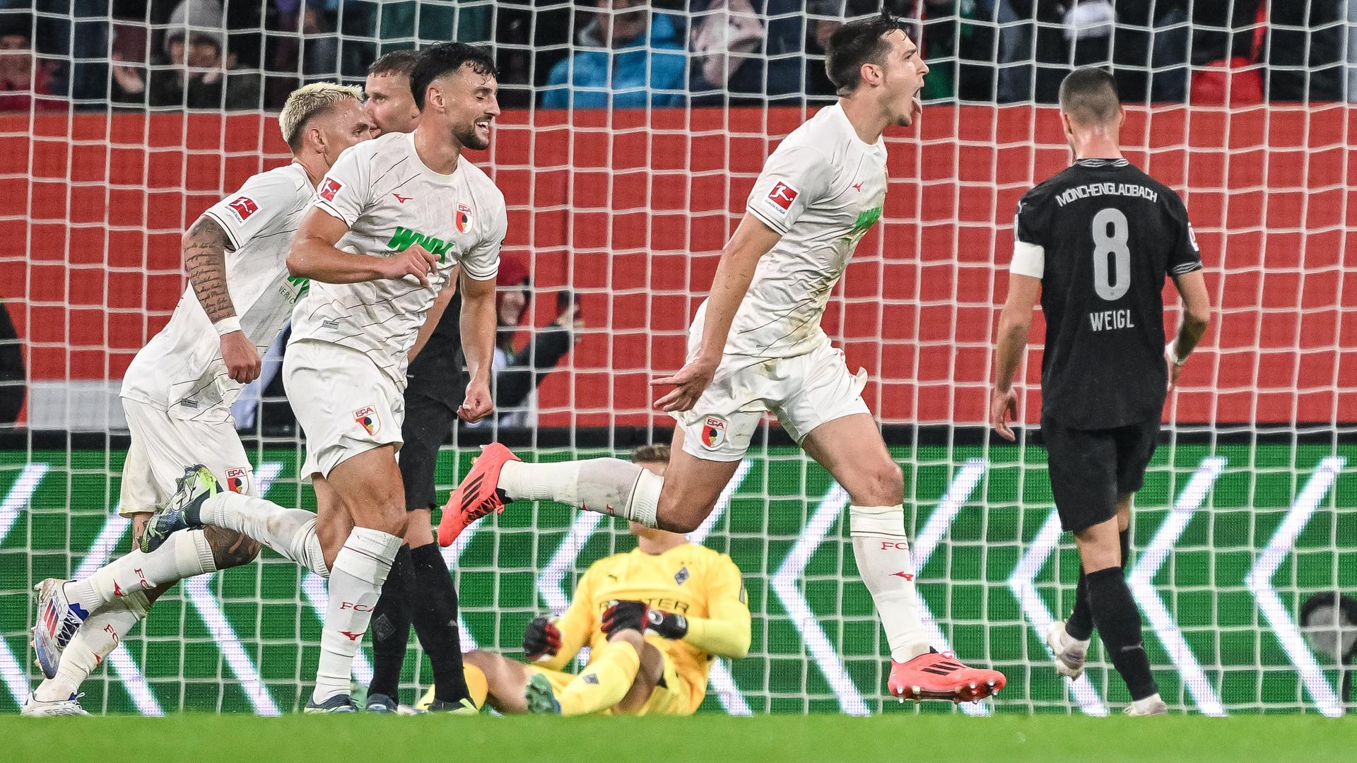 Fußball-Bundesliga, FC Augsburg - Bor. Mönchengladbach: Augsburgs Keven Schlotterbeck (r.) jubelt nach seinem Tor zum 1:0.