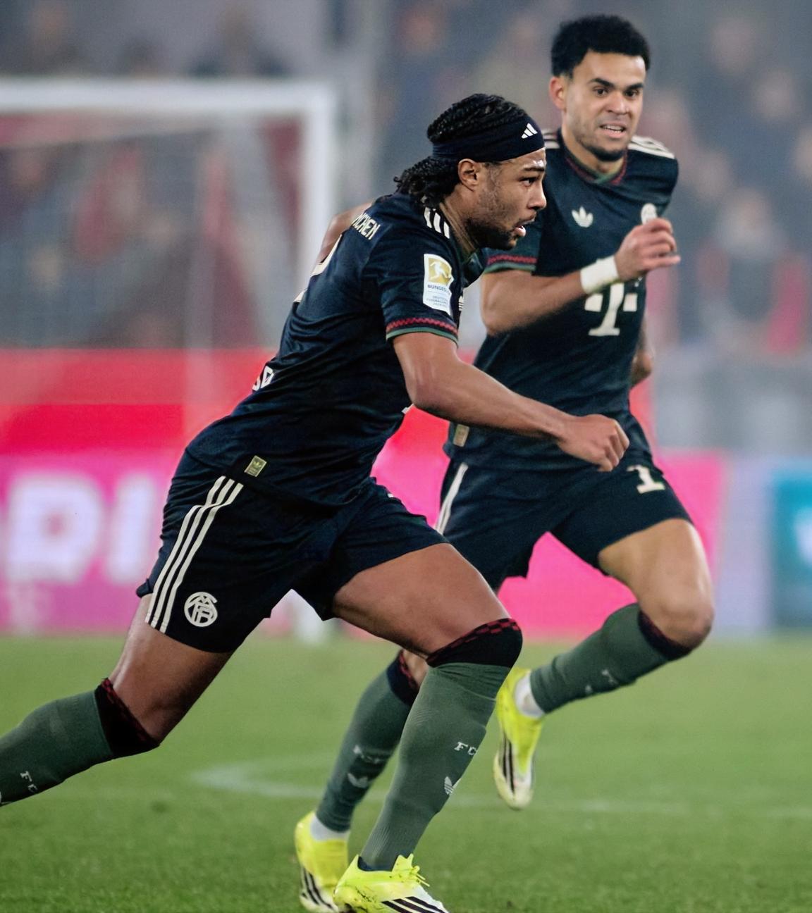 Serge Gnabry (FC Bayern) erzielt den Ausgleich zum 1:1 gegen Marvin Schwäbe (1. FC Köln), während Jan Thielmann (1. FC Köln) beteiligt ist. 1. FC Köln – Bayern München.