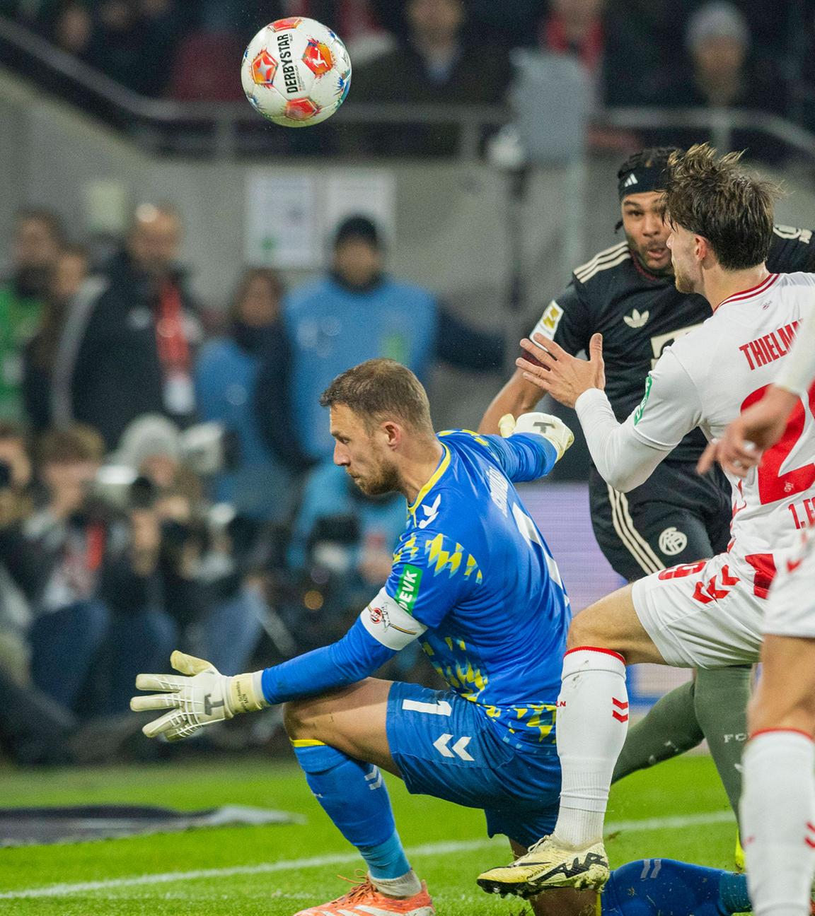 Serge Gnabry (FC Bayern) erzielt den Ausgleich zum 1:1 gegen Marvin Schwäbe (1. FC Köln), während Jan Thielmann (1. FC Köln) beteiligt ist. 1. FC Köln – Bayern München.