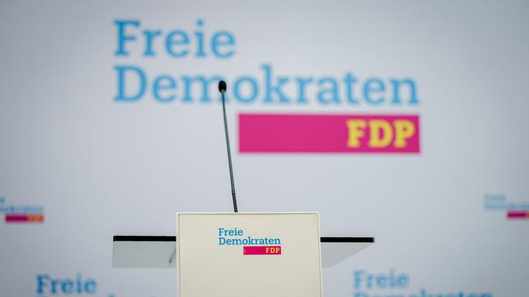 Ein Mikrofon ist vor dem Logo der Freien Demokraten FDP im Hans-Dietrich-Genscher-Haus vor der Pressekonferenz nach der Landtagswahl in Baden-Württemberg zu sehen.
