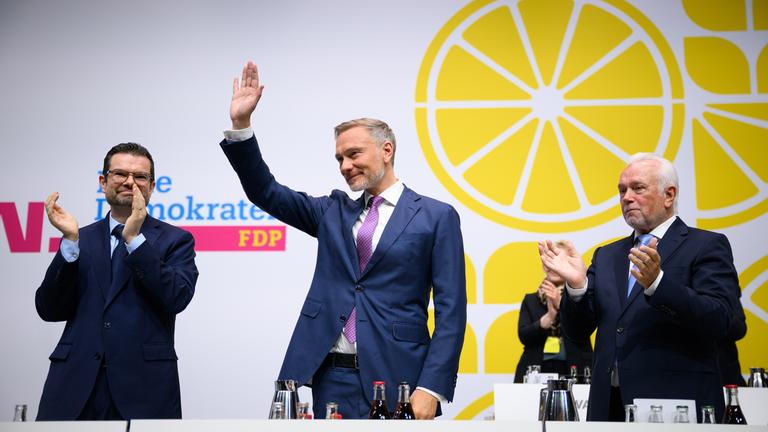 Christian Lindner, bisheriger Bundesvorsitzender der FDP, nimmt beim 76. Ordentlichen Bundesparteitag der FDP Applaus entgegen. Neben ihm stehen Marco Buschmann (l), FDP-Generalsekretär, und Wolfgang Kubicki (r, FDP). Beim ersten Parteitag der Freien Demokraten nach dem Scheitern bei der Bundestagswahl soll über den weiteren Kurs und eine neue Parteispitze abgestimmt werden.