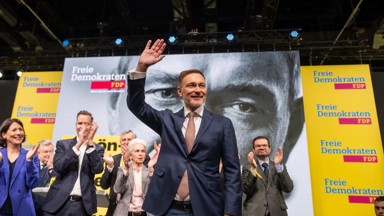 Christian Lindner, FDP Bundesvorsitzender, steht nach seiner Rede beim außerordentliche Bundesparteitag der FDP vor der Bundestagswahl winkend auf der Bühne.
