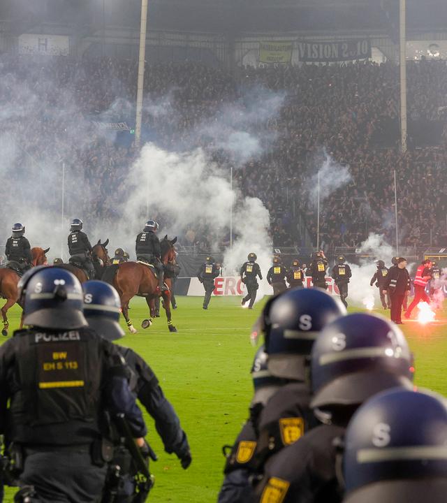 Während der DFB-Pokalpartie zwischen Waldhof Mannheim und dem 1. FC Kaiserslautern muss die Polizei das Feld stürmen
