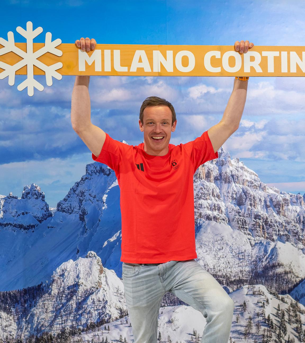 Der deutsche Rennrodler Felix Loch steht, während der Einkleidung für die Winterspiele in Mailand, für ein Foto vor einer Fotowand mit Bergpanorama.