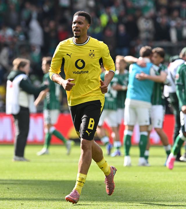 Felix Nmecha läuft im BVB Trikot über den Platz in einem Stadion.