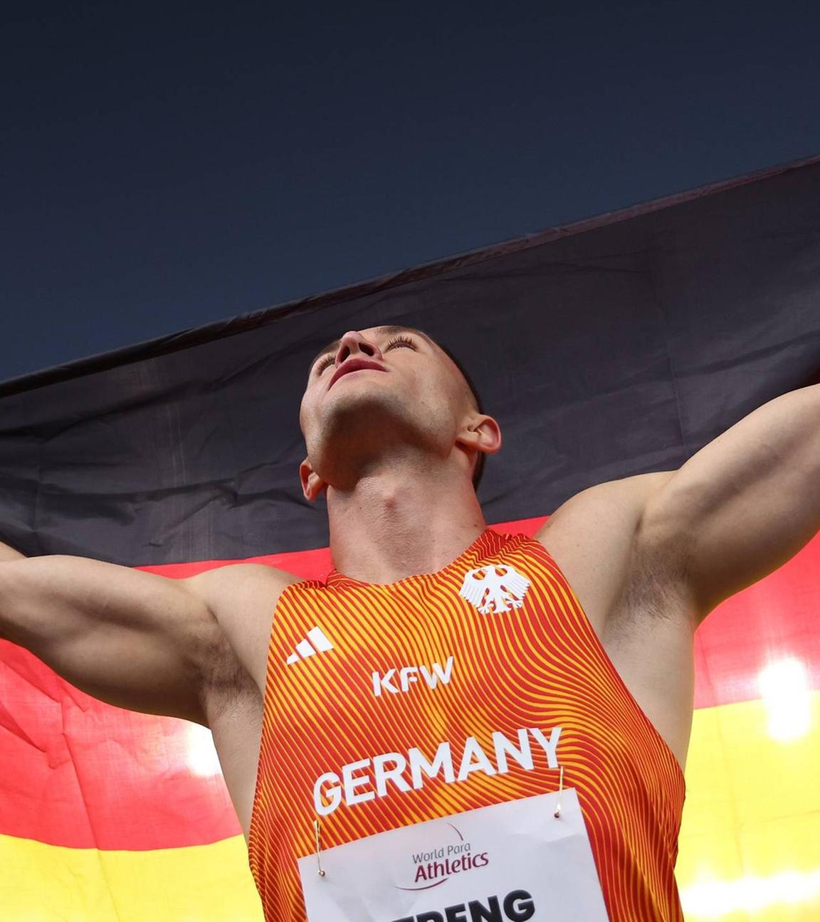 Felix Streng vom Team Deutschland gewinnt am 30.09.2025 bei der Para-Leichtathletik-WM in Neu-Delhi Gold im 100-Meter-Finale (T64) und jubelt mit der deutschen Flagge.