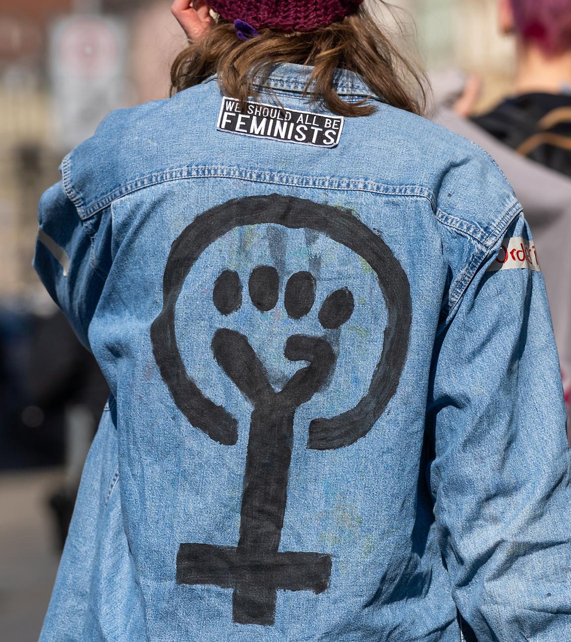 Eine Frau trägt Kleidung mit Feminismussymbol und geballter Faust (Archivfoto)