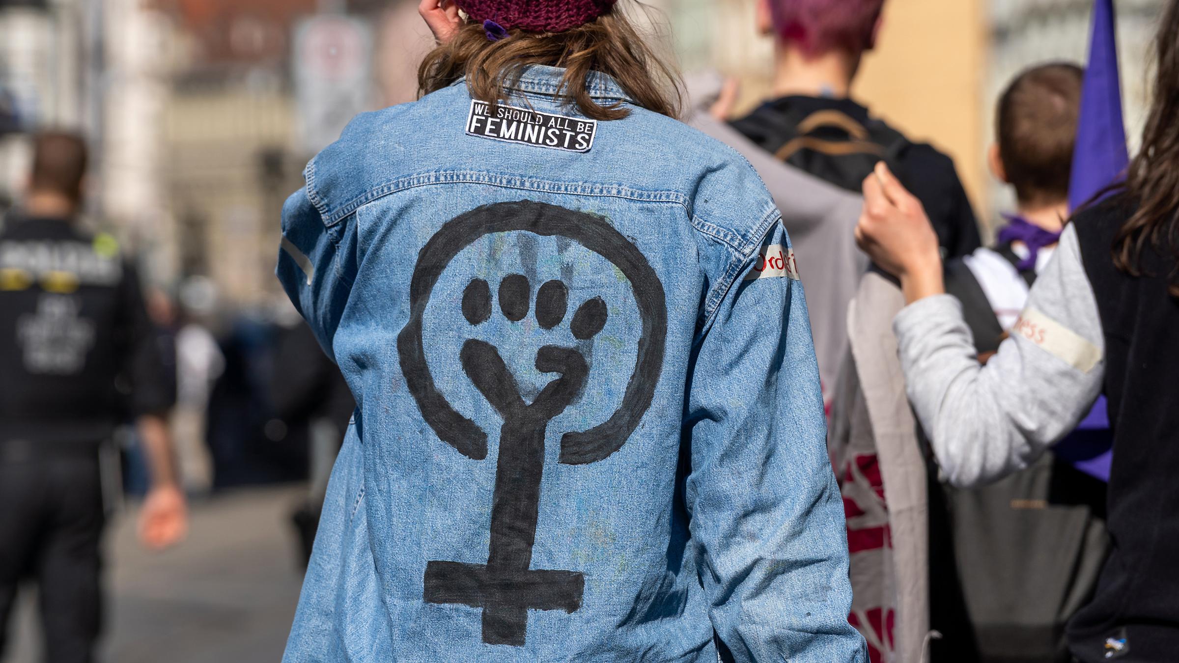 Eine Frau trägt Kleidung mit Feminismussymbol und geballter Faust (Archivfoto)