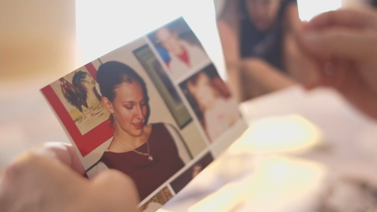 Foto einer jungen Frau wird von einer Frau in der Hand gehalten.