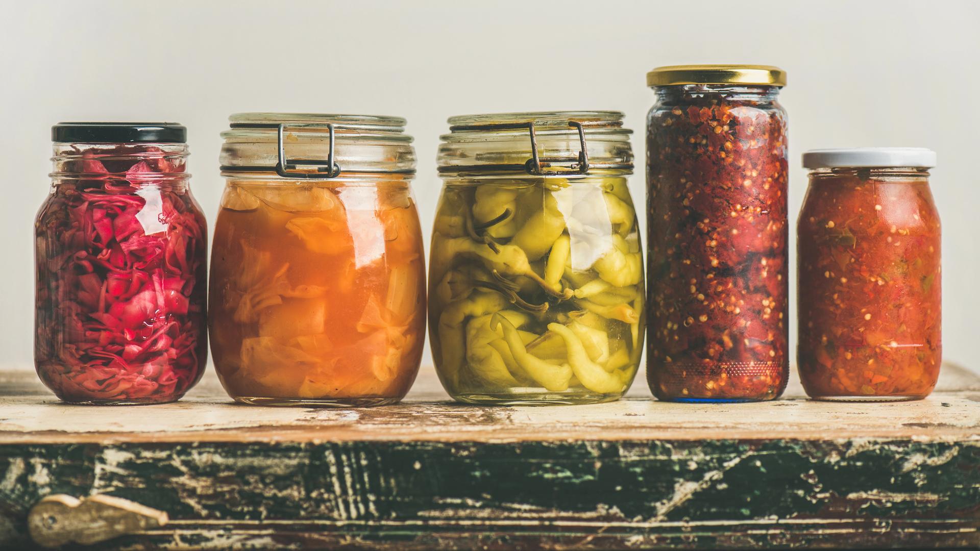 Fünf Einmachgläser mit fermentierten Lebensmitteln