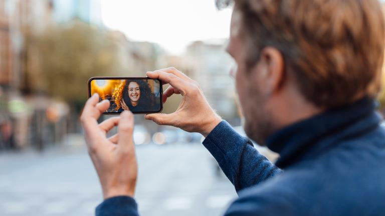 Ein Mann spricht per Video-Telefonie mit einer Frau.