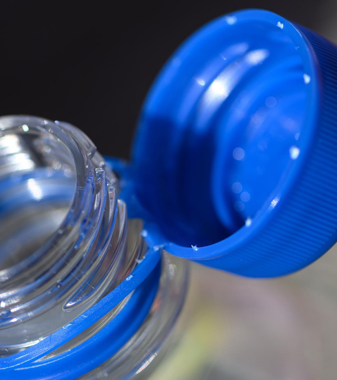 Eine Wasserflasche mit geöffneten Verschluss steht auf einem Tisch