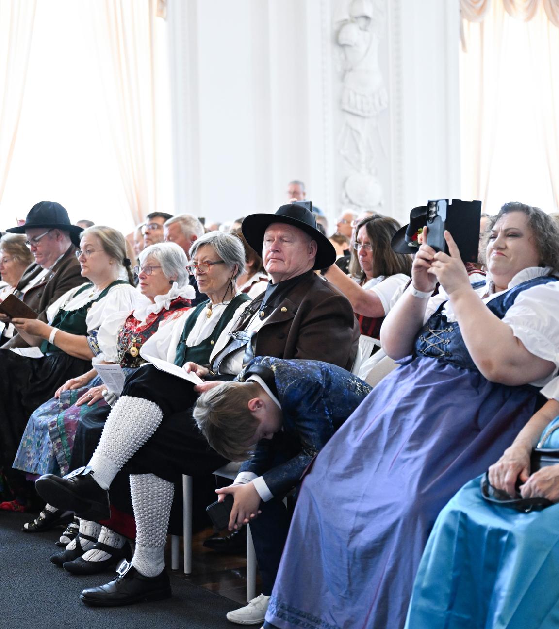 05.08.2025, Baden-Württemberg, Stuttgart: Mitglieder vom Bund der Vertriebenen sitzen in Tracht beim Festakt 75 Jahre Charta der deutschen Heimatvertriebenen im Neuen Schloss.