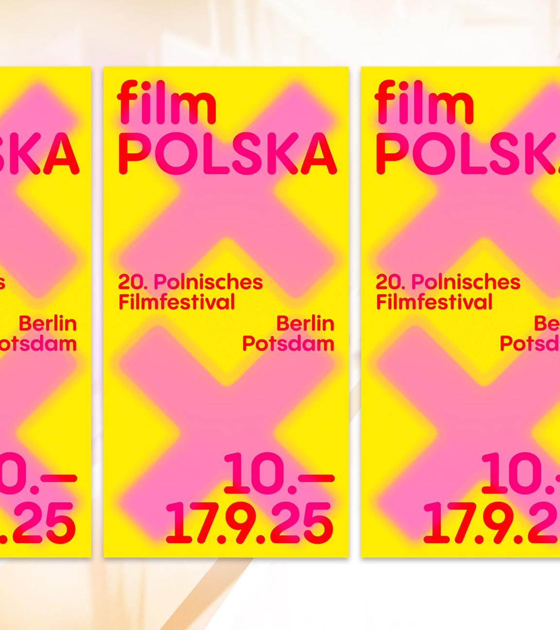 Auf einem gelben Plakat steht mit pinker Schrift der Festivaltitel geschrieben.