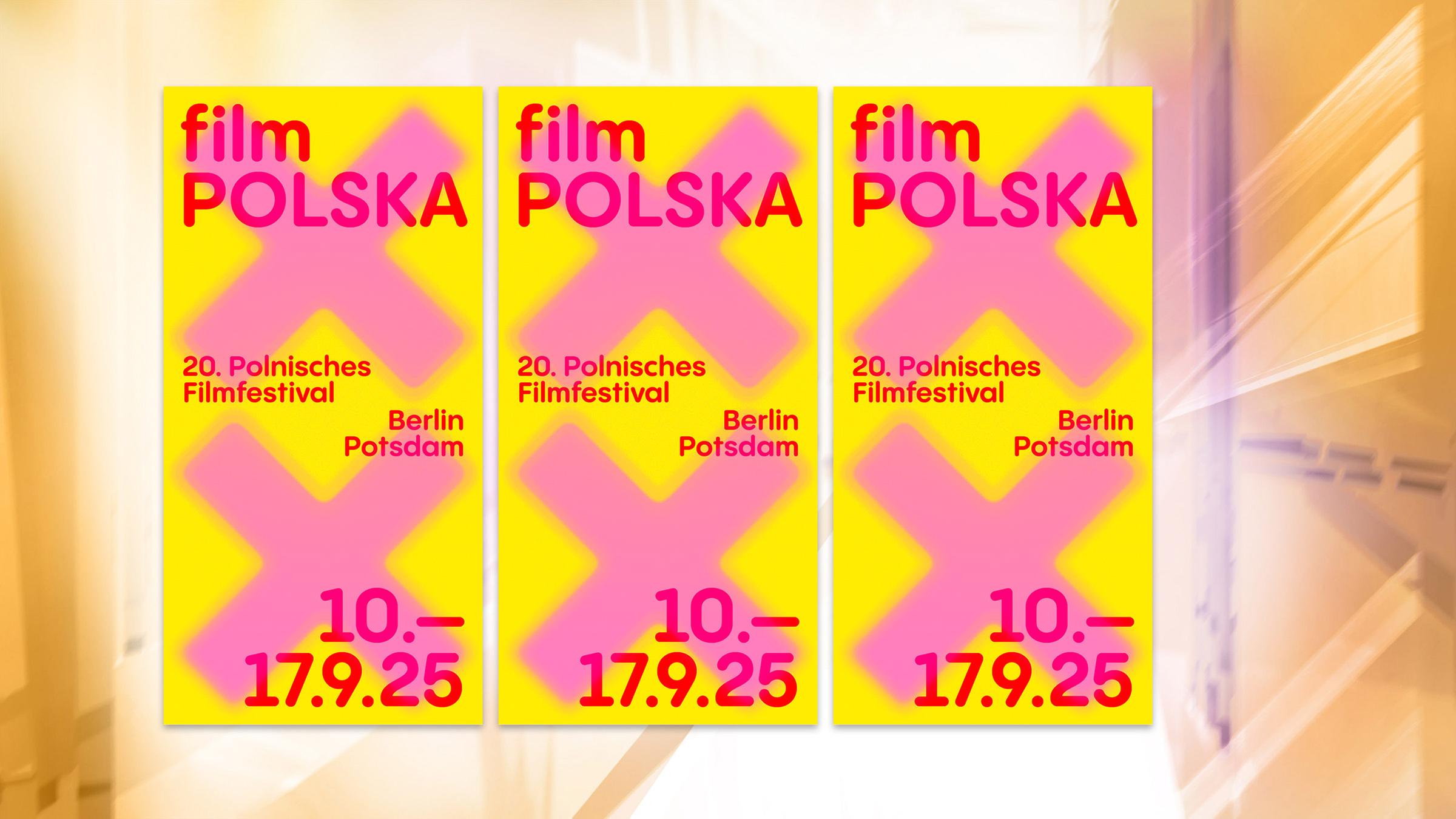 Auf einem gelben Plakat steht mit pinker Schrift der Festivaltitel geschrieben.