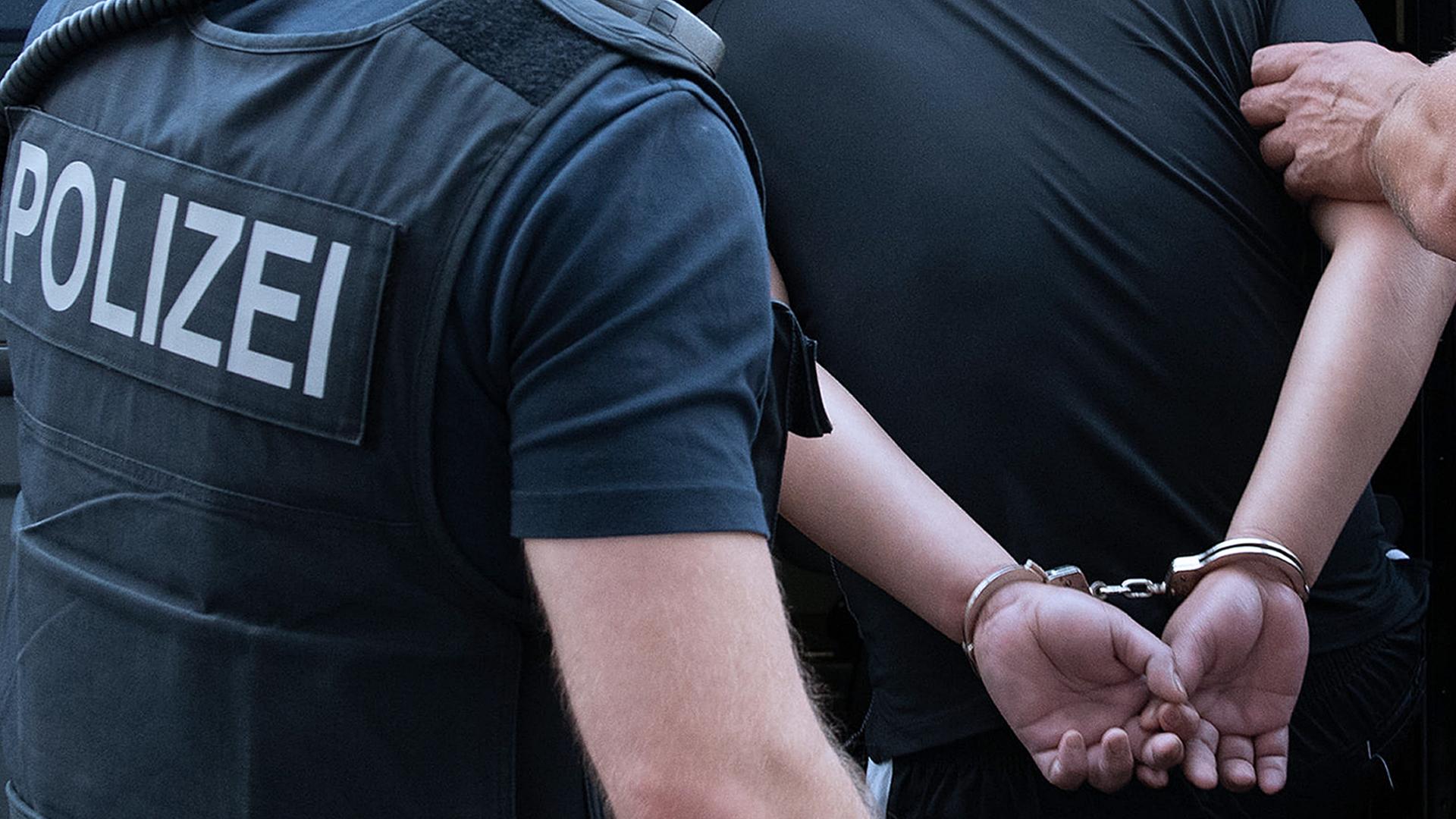 Archiv: Polizisten nehmen während einer Razzia einen Mann fest