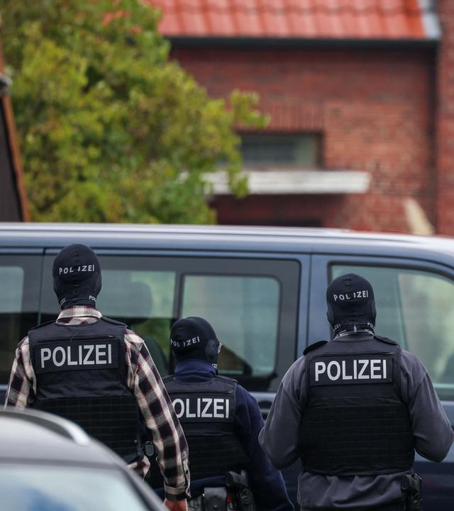  Polizeibeamte stehen vor dem Wohnhaus des ehemaligen BND-Präsidenten Hanning, der am Morgen unter Spionageverdacht festgenommen worden ist