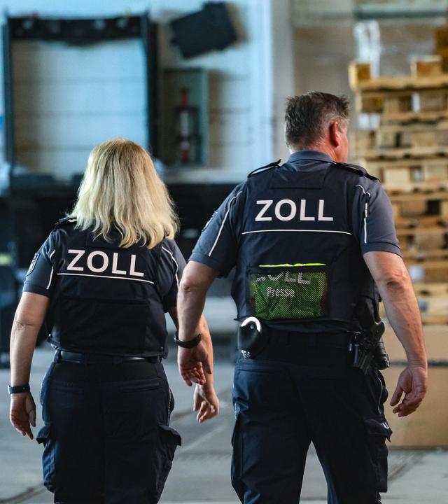 Nordrhein-Westfalen, Haan: Zwei Beamte des Zolls in einer Lagerhalle