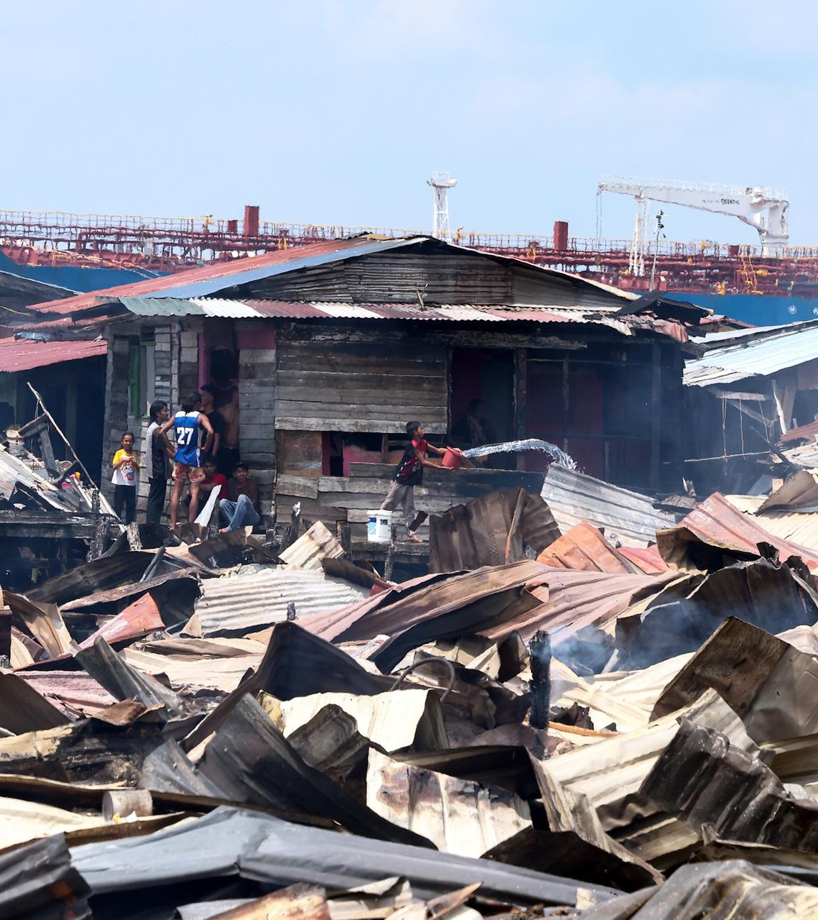 Trümmer liegen nach einem Brand in einem Küstendorf in Sabah, Malaysia, am 19.04.2026.