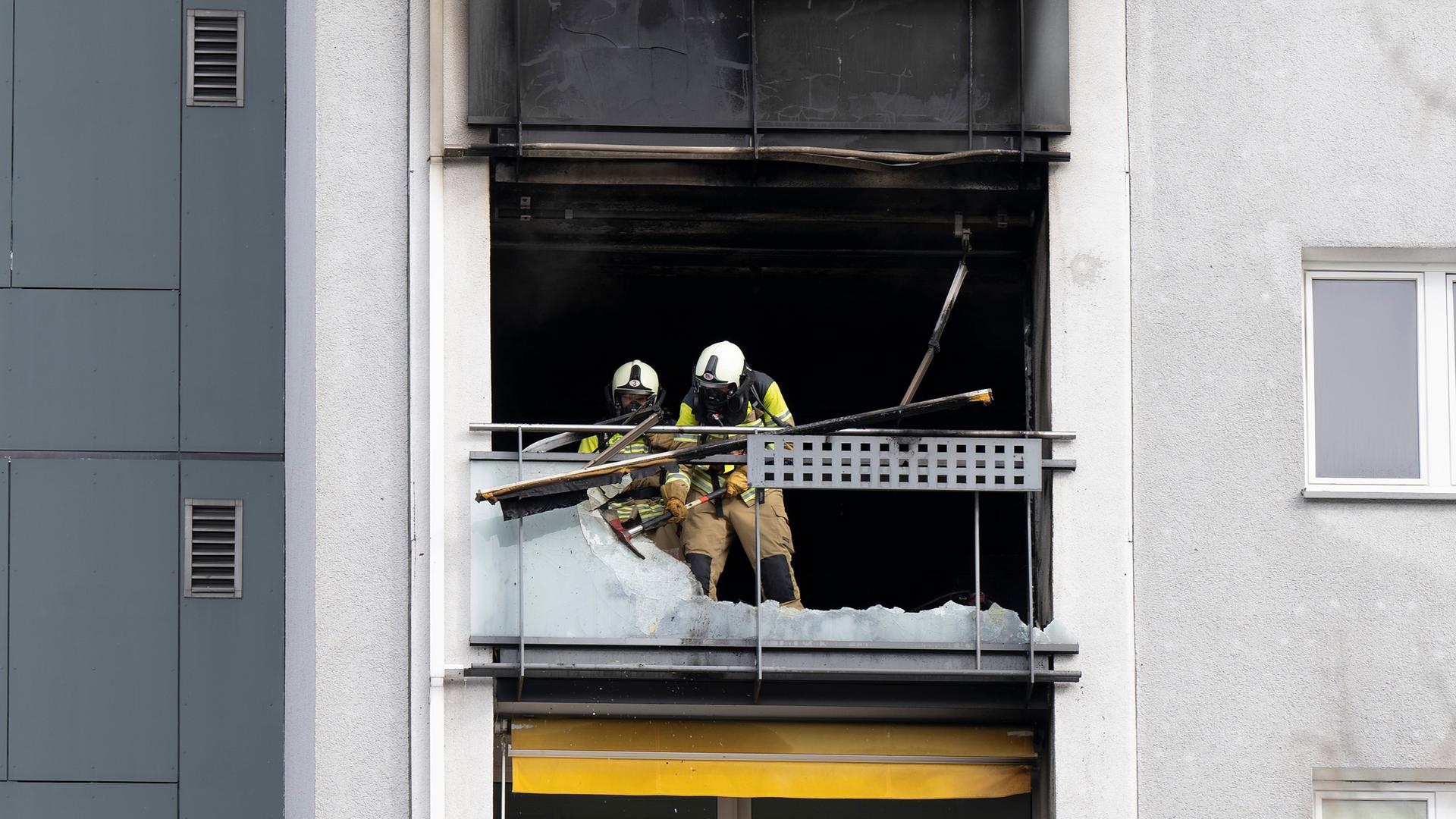 Einsatzkräfte der Feuerwehr stehen nach einem Brand in der elften Etage eines Dresdner Hochhauses am Einsatzort, aufgenommen am 15.02.2025