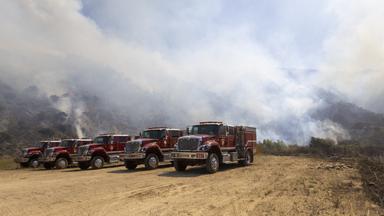 Feuerwehrautos stehen nahe des Sandy Fire in Simi Valley in Kalifornien bereit, während Einsatzkräfte gegen den Waldbrand kämpfen.