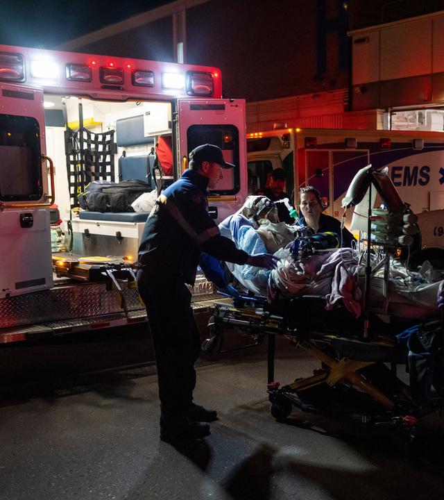 Sanitäter verarzten eine verletzte Person vor einem Krankenwagen auf der Militärbasis in Wainwright, Alberta.