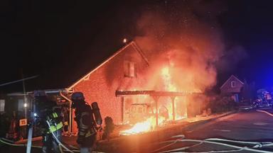 Feuerwehr versucht ein brennendes Haus zu löschen